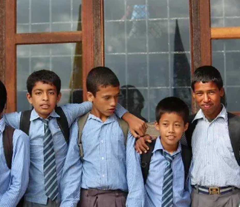 Nepali school boys standing in front of a window